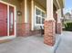 Inviting front porch with brick columns and a cozy seating area at 11060 River Oaks Ln, Commerce City, CO 80640