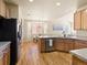 Open concept kitchen with stainless appliances, hardwood floors, and an eat-in dining area at 11060 River Oaks Ln, Commerce City, CO 80640