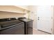 Functional laundry room with modern washer and dryer units and practical shelving at 11060 River Oaks Ln, Commerce City, CO 80640