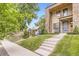 Modern townhome featuring a stone facade, front yard with grass and concrete steps at 4170 Vrain St, Denver, CO 80212