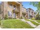 Modern townhome featuring a stone facade, balcony, and well-manicured front lawn and concrete steps at 4170 Vrain St, Denver, CO 80212