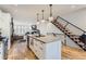 Open-concept kitchen with island seating and stainless appliances flows into the living room and a staircase at 4170 Vrain St, Denver, CO 80212