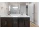 Bright bathroom featuring a double sink vanity, quartz countertop, and a glass-enclosed shower at 4543 Cholla Trl, Castle Rock, CO 80104