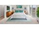 Inviting bedroom with white bedding, teal accents, and sliding glass doors leading to a balcony at 4543 Cholla Trl, Castle Rock, CO 80104