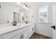 Double sink bathroom vanity with white cabinets, dark hardware, and wood-look flooring at 1131 Joseph Pl, Erie, CO 80026