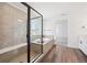 Modern bathroom showcasing a glass shower enclosure, soaking tub, and wood-look flooring at 1131 Joseph Pl, Erie, CO 80026