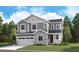 Two-story house with gray siding, stone accents, and a three-car garage at 1131 Joseph Pl, Erie, CO 80026