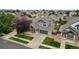 Aerial view of the blue home and neighborhood featuring mature trees and lawns at 15378 E 99Th Way, Commerce City, CO 80022