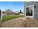 Stone and grass yard with sliding glass door entry into the blue house and fence at 15378 E 99Th Way, Commerce City, CO 80022