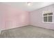 Pink bedroom featuring plush carpeting, a window, and a cute, unique, wall design at 15378 E 99Th Way, Commerce City, CO 80022