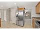 Stainless steel refrigerator in kitchen next to eat-in area and archway into living room at 15378 E 99Th Way, Commerce City, CO 80022