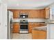 Eat-in kitchen with stainless steel appliances and wood cabinetry with tile flooring at 15378 E 99Th Way, Commerce City, CO 80022