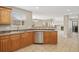 Kitchen features stainless steel dishwasher and sink with pass through opening to living room at 15378 E 99Th Way, Commerce City, CO 80022