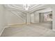 Bright living room with plush gray carpet, white staircase, tile entry, and natural light from a large window at 15378 E 99Th Way, Commerce City, CO 80022