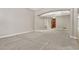 Spacious living room with neutral walls, plush gray carpet, arched entryways, and an elegant tray ceiling with chandelier at 15378 E 99Th Way, Commerce City, CO 80022
