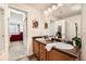 Double vanity in bathroom with tan cabinets, a large mirror, and an adjoining bedroom at 10056 W Unser Dr # 204, Littleton, CO 80127
