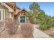 Attractive building entrance featuring stone accents and wood trim with a manicured landscape setting at 10056 W Unser Dr # 204, Littleton, CO 80127