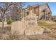 Stone community sign for Chatfield Bluffs situated among natural landscaping and community buildings at 10056 W Unser Dr # 204, Littleton, CO 80127