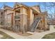 Condo exterior shows a brown multi-story building with stone accents and metal staircase at 10056 W Unser Dr # 204, Littleton, CO 80127