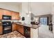 Functional kitchen featuring wood cabinets, island with bar seating, and open to the adjacent living room at 10056 W Unser Dr # 204, Littleton, CO 80127