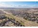 Expansive aerial view of a suburban neighborhood, featuring power lines, roads, and houses, set against a distant skyline at 21593 Hill Gail Way, Parker, CO 80138