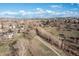 Wide aerial view of a residential area featuring a walking path and houses surrounded by open fields and natural landscapes at 21593 Hill Gail Way, Parker, CO 80138