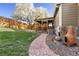 Backyard with stone pathway leading to a covered patio and featuring decorative elements and lush greenery at 21593 Hill Gail Way, Parker, CO 80138