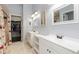 Bathroom with dual vanity, updated mirrors, and closet access at 21593 Hill Gail Way, Parker, CO 80138