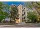 View of the building exterior from street level surrounded by mature trees and landscaping at 800 N Pearl St # 1211, Denver, CO 80203