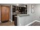 Modern kitchen with bar, dark cabinets and backsplash, stainless steel appliances, and wood floors at 800 N Pearl St # 1211, Denver, CO 80203