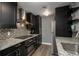 Modern kitchen featuring stainless steel appliances, dark cabinetry, granite countertops, and mosaic tile backsplash at 800 N Pearl St # 1211, Denver, CO 80203