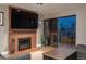 Comfortable living room features a brick fireplace, a large television, and access to the balcony with a beautiful city view at 800 N Pearl St # 1211, Denver, CO 80203