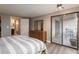 Bright main bedroom with wood flooring, dresser and access to the balcony overlooking city views at 800 N Pearl St # 1211, Denver, CO 80203
