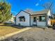 White house with black accents, landscaping, and a gravel driveway at 886 Kenton St, Aurora, CO 80010