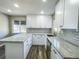 Modern kitchen featuring white cabinets, granite countertops, and a breakfast bar at 886 Kenton St, Aurora, CO 80010