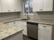 L-shaped kitchen with granite countertops and stainless steel dishwasher at 886 Kenton St, Aurora, CO 80010