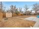 Large backyard with privacy fence, storage shed, concrete patio and sparse landscaping at 956 Racine St, Aurora, CO 80011