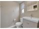 This bathroom features a updated vanity, toilet, and a window that lets in natural light at 956 Racine St, Aurora, CO 80011