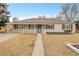 Exterior view of the home features a covered entry, well-kept lawn, and a clean facade at 956 Racine St, Aurora, CO 80011