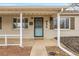 Close-up of charming home featuring covered front porch and stylish front door at 956 Racine St, Aurora, CO 80011