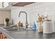 Close up of stainless steel sink, tile backsplash, and butcher block countertop at 956 Racine St, Aurora, CO 80011