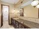 Bathroom with marble countertop vanity, large mirror, and vintage lighting fixtures at 6155 Meadowbrook Dr, Morrison, CO 80465