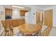 Eat-in kitchen area featuring a wooden dining table, wooden cabinetry, and white appliances at 6155 Meadowbrook Dr, Morrison, CO 80465