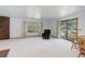 Spacious living room featuring carpet flooring, a fireplace, ample natural light, and a cozy armchair at 6155 Meadowbrook Dr, Morrison, CO 80465