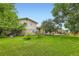 Green backyard with mature trees and a covered patio offers a serene outdoor space at 1497 S Oakland St, Aurora, CO 80012