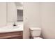 Powder room features a toilet, a mirror, and a vanity with a white sink at 1497 S Oakland St, Aurora, CO 80012