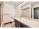Bathroom features a shower with glass door, toilet, and sink with countertop with large mirror and vanity lights at 1497 S Oakland St, Aurora, CO 80012