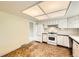 Well-lit kitchen offers white cabinets, a gas range, and durable wood-style flooring at 1497 S Oakland St, Aurora, CO 80012