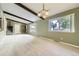 Bright, open living space with exposed beams, neutral carpet, and large windows at 1497 S Oakland St, Aurora, CO 80012