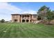 Expansive backyard with manicured lawn, stone accents and multiple levels of outdoor living spaces at 6371 Diamond Ridge Pkwy, Castle Rock, CO 80108